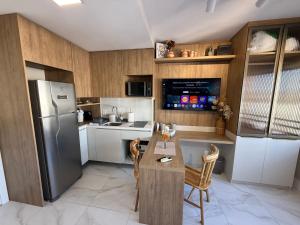 a kitchen with a refrigerator and a table and chairs at Studio JP Redenção in Porto Alegre