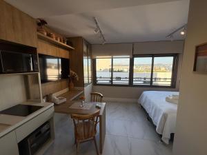 a kitchen and a bedroom with a bed and a table at Studio JP Redenção in Porto Alegre