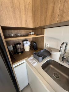 a kitchen with a sink and a microwave at Studio JP Redenção in Porto Alegre +40 photos