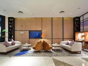 a living room with two couches and a flat screen tv at Mercure Qidong Downtown in Qidong