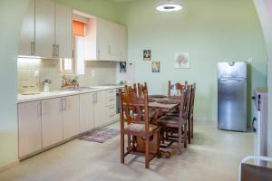 a kitchen with a table and chairs and a refrigerator at Oliva Mare I in Agia Fotia