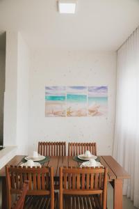 a dining room with a wooden table and chairs at Curima Milagres in Passo de Camarajibe