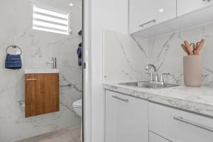 a white bathroom with a sink and a toilet at Bay View by Otium in Catano +48 photos