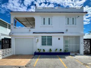 a white house with a garage at Bay View by Otium in Catano