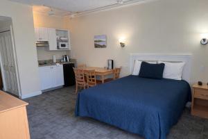a bedroom with a bed and a table and a kitchen at Courtyard Resort in Hyannis
