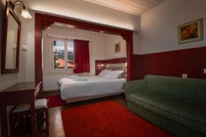 a hotel room with a bed and a couch at Guesthouse Mavrodimos in Eptalofos
