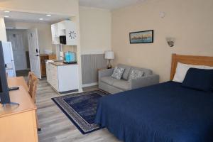 a bedroom with a bed and a couch and a kitchen at Courtyard Resort in Hyannis