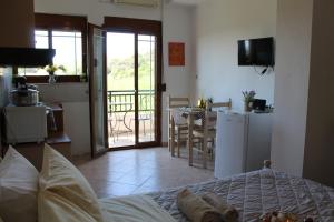 a bedroom with a bed and a kitchen with a balcony at Vakis Apartments 2 in Romanón