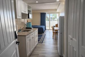 a kitchen with a sink and a room with a bed at Courtyard Resort in Hyannis