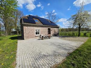 a house with solar panels on the roof at Die alte Waldkate - Windschief und mitten in der Natur in Kevelaer