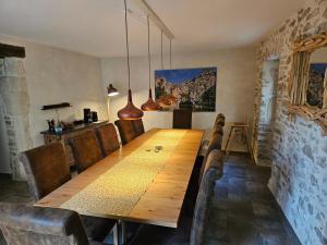 a dining room with a wooden table and chairs at L'EMPREINTE in Salavas