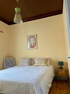 a bedroom with a white bed with a wooden ceiling at Casa Terra in Rio Maior