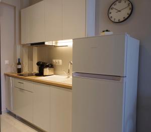 a kitchen with a refrigerator and a clock on the wall at Sithonian Sunset Luxury Apartments in Skála Nikíta +30 photos