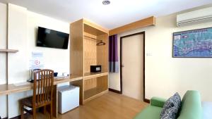 a living room with a green couch and a tv at Sea Place Pattaya Soi 7 in Pattaya +17 photos