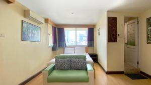 a hotel room with a bed and a green couch at Sea Place Pattaya Soi 7 in Pattaya
