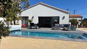 a house with a swimming pool in front of a house at Villa Lagune in Les Sables-d'Olonne