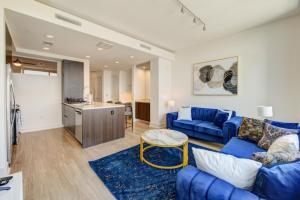 a living room with a blue couch and a kitchen at Hanover River Oaks in Houston