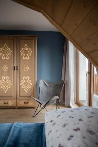 a bedroom with a chair and a bed and a cabinet at Willa Widokowe Wzgórze in Falsztyn