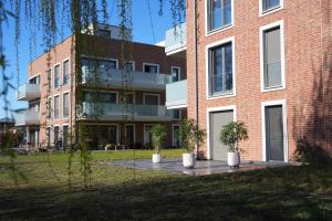 a brick building with potted plants in front of it at Ruppiner Seeblick Ferienwohnungen in Neuruppin