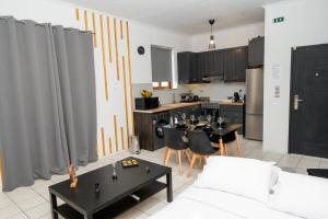 a kitchen and a living room with tables and chairs at Ottoka in Kos