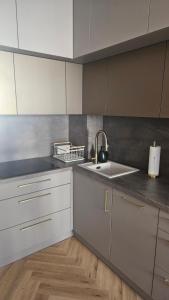 a kitchen with white cabinets and a sink at Apartament Premium in Biała Podlaska