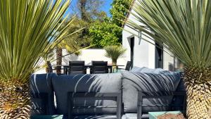 a patio with a couch and chairs and palm trees at Villa Lagune in Les Sables-d'Olonne