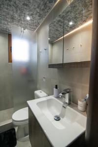 a bathroom with a white sink and a toilet at Ottoka in Kos