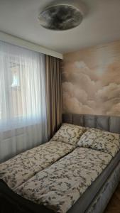 a bed in a bedroom with a painting on the wall at Apartament Premium in Biała Podlaska