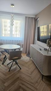 a living room with a table and a tv at Apartament Premium in Biała Podlaska