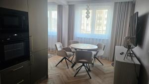 a living room with a table and chairs and a television at Apartament Premium in Biała Podlaska