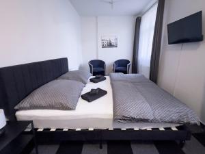 a bedroom with a bed with two chairs in it at Hotel Central in Ostrava