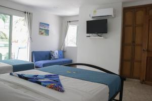 a hotel room with two beds and a tv at Casa de Mony in Santa Marta