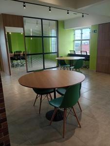 a room with tables and chairs and green walls at Studio Aura in Barbacena