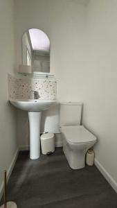 a white bathroom with a sink and a toilet at Newly refurbished Annexe in Wareham