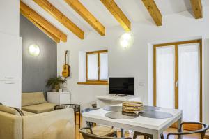 a living room with a table and a tv at Windshouse Apartments in Nago-Torbole