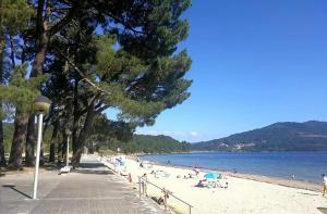 a beach with a bunch of people on the beach at Hostal Viña in Outes +2 photos