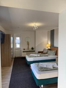 a hotel room with two beds and a couch at Hellwig Ferienwohnung 5 in Bernburg