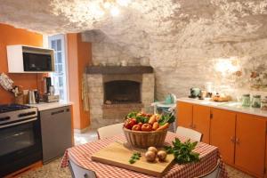a kitchen with a table with a basket of fruits and vegetables at Les rives enchantées in Loches
