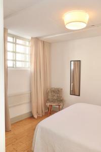 a bedroom with a bed and a chair and a window at Kville Hostel in Gothenburg