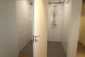 a bathroom with a shower with a door at Kville Hostel in Gothenburg
