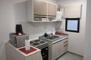 a small kitchen with a stove and a microwave at México 1510 - Neuquén Centro in Neuquén