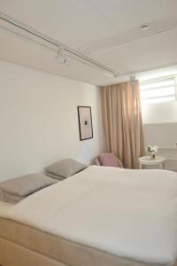 a bedroom with a white bed and a window at Kville Hostel in Gothenburg +11 photos