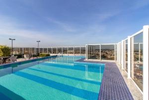 a large swimming pool on top of a building at Sweet Studio - GRU 19º in Guarulhos