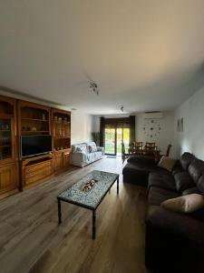 a living room with a couch and a table at Apartamentos rurales El Hondón del Lugar in Hoyos