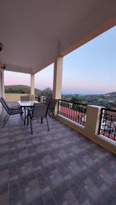 a patio with a table and chairs on a balcony at MAFILVI Panorama in Chrousa