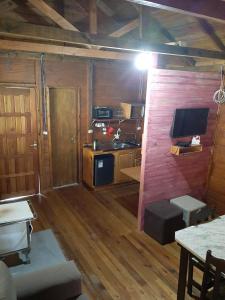 a small room with a kitchen and a tv in it at Chalés sítio anjo gabriel 3 in Urubici
