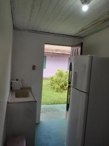 a kitchen with a refrigerator and a door to a yard at Nosso Lar in Porto Velho
