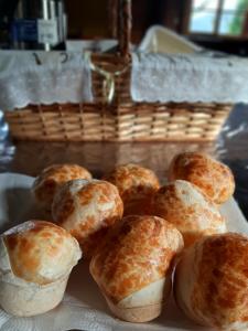a plate of pastries on a table with a basket at Chalés sítio anjo gabriel 3 in Urubici