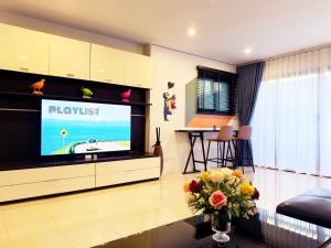 a living room with a flat screen tv at THE MAISON Phuket in Ban Lo Long