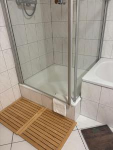 a shower with a wooden mat in a bathroom at Privatquartier im Ortskern von Westerstede in Westerstede +7 photos